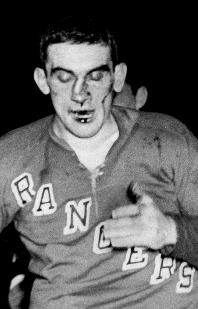 New York Rangers defenseman Lou Fontinato, his nose broken and bent towards his ear, heads to the dressing room after a five minute fight with Detroit Red Wings' Gordie Howe during NHL action at Madison Square Garden on Feb. 2, 1959. The Canadian Press/AP/New York Daily News